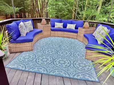 a blue couch sitting on a deck with a rug at Bethel Escape Hot Tub 4 beds Game Room and Fire pit Fully Stocked Kitchen in Smallwood