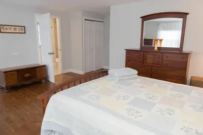 a bedroom with a bed and a dresser and a mirror at Spacious Modern Home in West Freehold in Stonehurst West