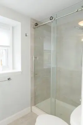 a shower with a glass door in a bathroom at Spacious Modern Home in West Freehold in Stonehurst West