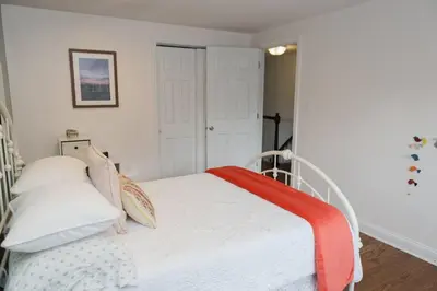 a bedroom with a bed with a red blanket on it at Spacious Modern Home in West Freehold in Stonehurst West