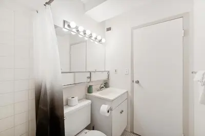 a white bathroom with a toilet and a mirror at PP 2107 Beautiful 1Br Apartment I Free Parking in Harrisburg