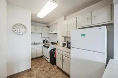 a kitchen with white cabinets and a clock on the wall at PP 2107 Beautiful 1Br Apartment I Free Parking in Harrisburg