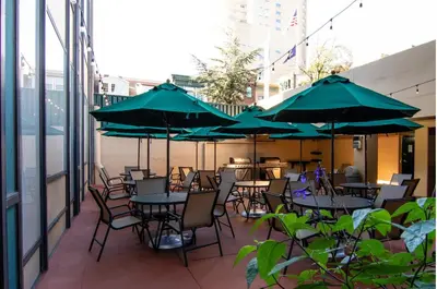 a patio with tables and chairs with green umbrellas at PP 2312 Modern Corporate 1br, pool, Gym in Harrisburg
