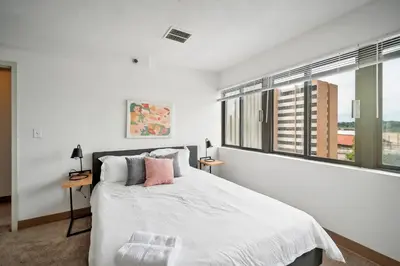 a white bedroom with a bed and a large window at PP 501 Harrisburg Gem 2br, Pool, Parking in Harrisburg