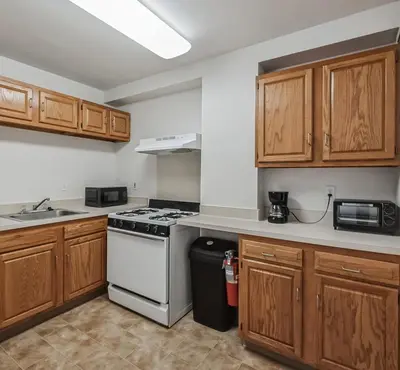 a kitchen with wooden cabinets and a stove top oven at PP 501 Harrisburg Gem 2br, Pool, Parking in Harrisburg