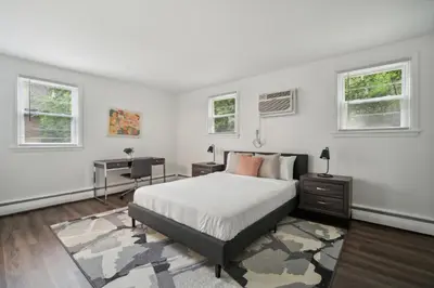 a white bedroom with a bed and two windows at Pine Brook 104 I Pool Gym I Free Parking ! in Newark