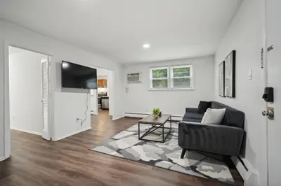 a living room with a couch and a television at Pine Brook 104 I Pool Gym I Free Parking ! in Newark