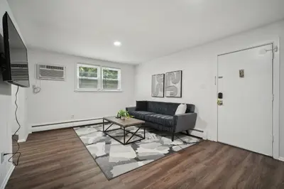 a living room with a couch and a table at Pine Brook 104 I Pool Gym I Free Parking ! in Newark