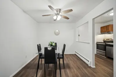 a dining room with a ceiling fan and a table with chairs at Pine Brook 104 I Pool Gym I Free Parking ! in Newark