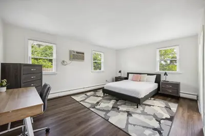 a bedroom with a bed and a desk and two windows at Pine Brook 1108 I Pool Gym I Free Parking ! in Newark