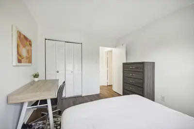 a white bedroom with a bed and a desk at Pine Brook 1108 I Pool Gym I Free Parking ! in Newark
