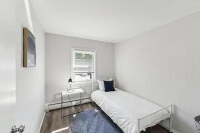 a white bedroom with a bed and a window at Pine Brook 1111 I State of the art 15 Bd Apt in Newark