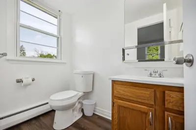 a bathroom with a toilet and a sink and a window at Pine Brook 1122 I Pool Gym I Free Parking ! in Newark