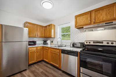 a kitchen with wooden cabinets and stainless steel appliances at Pine Brook 1122 I Pool Gym I Free Parking ! in Newark