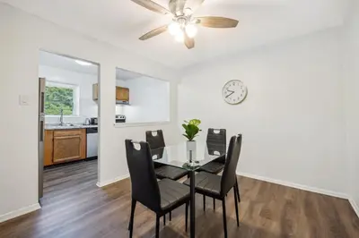 a dining room with a table and chairs and a clock at Pine Brook 1122 I Pool Gym I Free Parking ! in Newark
