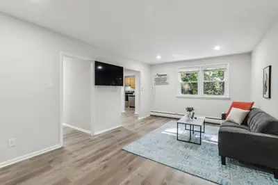 a living room with a couch and a table at Pine Brook 118 I Modern Corporate 2bd I Parking in Newark