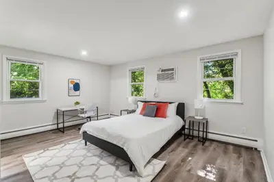 a white bedroom with a bed and two windows at Pine Brook 118 I Modern Corporate 2bd I Parking in Newark