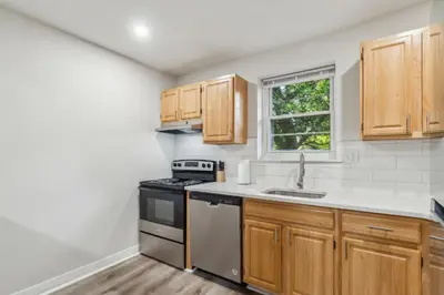a kitchen with wooden cabinets and a stove at Pine Brook 118 I Modern Corporate 2bd I Parking in Newark