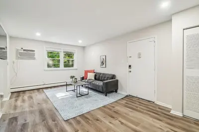 a living room with a couch and a table at Pine Brook 118 I Modern Corporate 2bd I Parking in Newark
