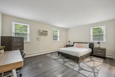 a bedroom with a bed and a desk and two windows at Pine Brook 120 I Pool Gym I Free Parking ! in Newark