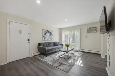 a living room with a couch and a table at Pine Brook 120 I Pool Gym I Free Parking ! in Newark