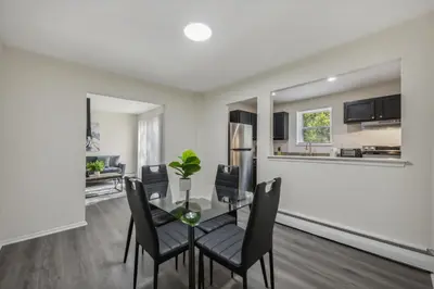 a dining room and living room with a table and chairs at Pine Brook 120 I Pool Gym I Free Parking ! in Newark