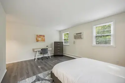 a white bedroom with a bed and a desk at Pine Brook 120 I Pool Gym I Free Parking ! in Newark