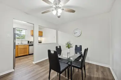 a dining room with a table and chairs and a clock at Pine Brook 1202 I Pool Gym I Free Parking ! in Newark