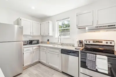 a white kitchen with white cabinets and appliances at Pine Brook 1218 I Cozy & comfy I Free Parking in Newark