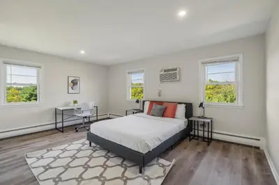 a bedroom with a bed and two windows at Pine Brook 124 I Modern Gem I Free Parking in Newark