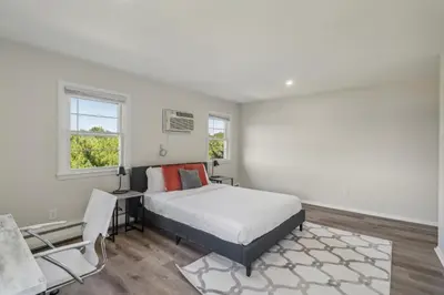 a white bedroom with a bed and a chair at Pine Brook 124 I Modern Gem I Free Parking in Newark