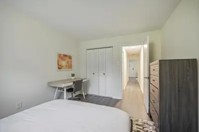 a white bedroom with a desk and a bed at Pine Brook 1302 I Pool Gym I Free Parking ! in Newark