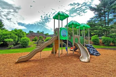 a playground with slides and umbrellas in a park at PineBrook 1406 I 2br Garden Style Apartment ! in Newark