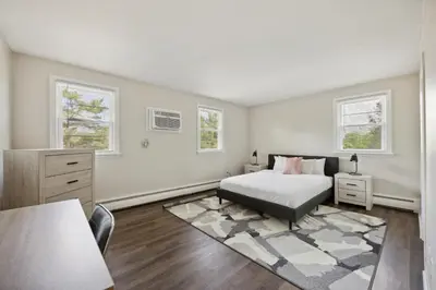 a bedroom with a bed and a dresser and two windows at PineBrook 1406 I 2br Garden Style Apartment ! in Newark