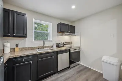 a kitchen with black cabinets and a sink at Pine Brook 410 I Pool Gym I Free Parking ! in Newark