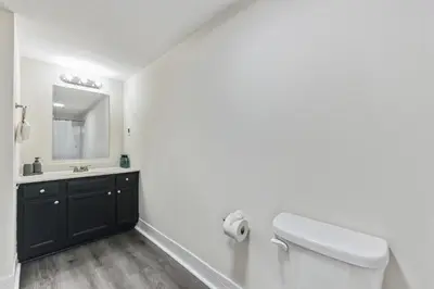 a white bathroom with a toilet and a sink at Pine Brook 410 I Pool Gym I Free Parking ! in Newark