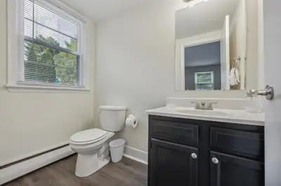 a bathroom with a toilet and a sink and a mirror at Pine Brook 410 I Pool Gym I Free Parking ! in Newark