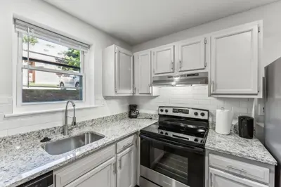 a kitchen with white cabinets and a sink and a stove at Pine Brook 416 I Corporate 15Br Apartment ! Pool in Newark