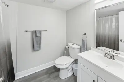 a white bathroom with a toilet and a sink at Pine Brook 416 I Corporate 15Br Apartment ! Pool in Newark