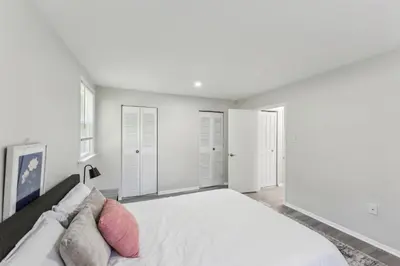 a white bedroom with a large bed with pillows at Pine Brook 416 I Corporate 15Br Apartment ! Pool in Newark