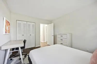 a white bedroom with a bed and a desk at Pine Brook 502 I Pool Gym I Free Parking ! in Newark