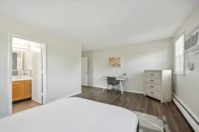 a white bedroom with a bed and a desk at Pine Brook 502 I Pool Gym I Free Parking ! in Newark