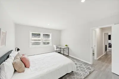 a white bedroom with a large bed and a window at Pine Brook 509 I Corporate 15Br Apt I Parking in Newark