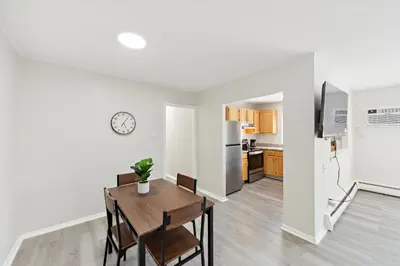 a kitchen and dining room with a table and a refrigerator at Pine Brook 509 I Corporate 15Br Apt I Parking in Newark