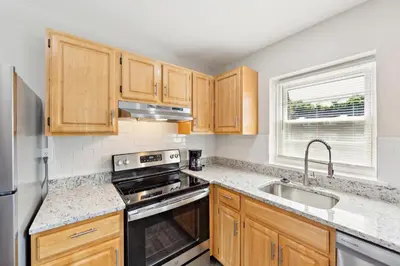 a kitchen with wooden cabinets and stainless steel appliances at Pine Brook 509 I Corporate 15Br Apt I Parking in Newark