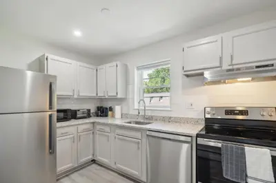 a kitchen with white cabinets and a stainless steel refrigerator at Pine Brook 518 I Spacious 2Bd Garden Style Oasis in Newark