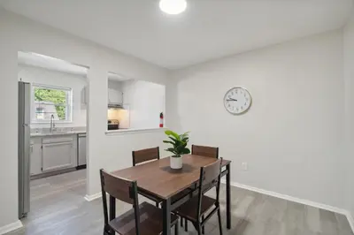 a dining room with a table and a clock on the wall at Pine Brook 518 I Spacious 2Bd Garden Style Oasis in Newark