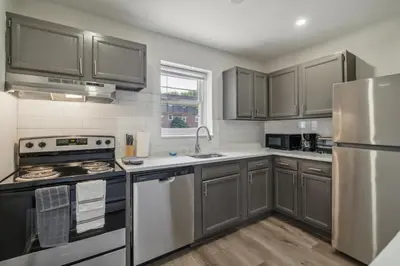 a kitchen with stainless steel appliances and gray cabinets at Pine Brook 618 I Cozy & Roomy I Gym & Pool in Newark