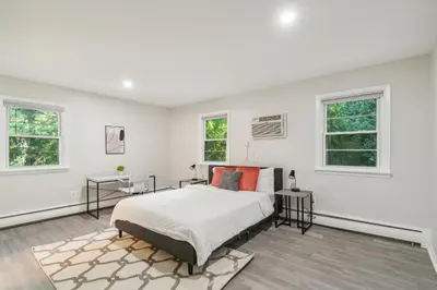 a white bedroom with a bed and two windows at Pine Brook 808 I Your Newark Retreat I Pool & Gym in Newark