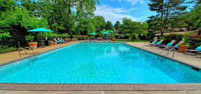 a large swimming pool with chairs and umbrellas at Pine Brook 808 I Your Newark Retreat I Pool & Gym in Newark